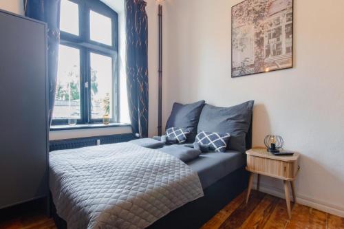 a bedroom with a blue bed and a window at TravelBase - Anklam in Anklam