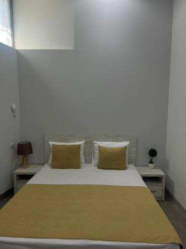 a bedroom with a large bed with yellow pillows at Hotel Menua in Yerevan