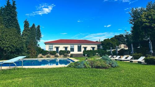 a house with a swimming pool in a yard at Quinta das Vianas - Casas do Picadeiro in Monção