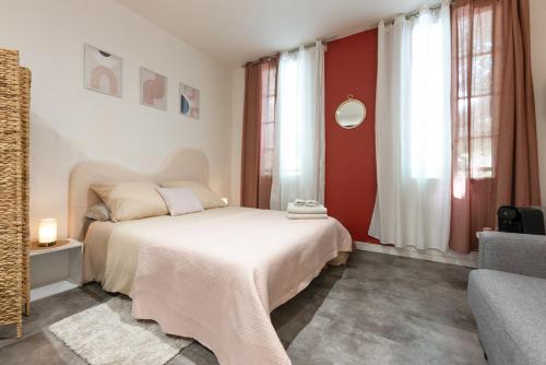 - une chambre avec un lit, un canapé et des fenêtres dans l'établissement La Casita - Studio Confort avec Parking privé - Lit douillet - Centre Uzès, Pont du Gard, à Uzès