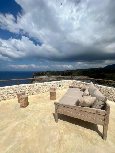 a bed with pillows sitting on top of a patio at Villa SOWILO Penida in Polilit