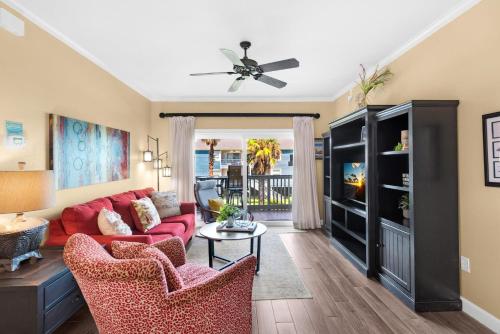 a living room with a red couch and chairs at Villas on the Gulf unit J7 in Pensacola Beach