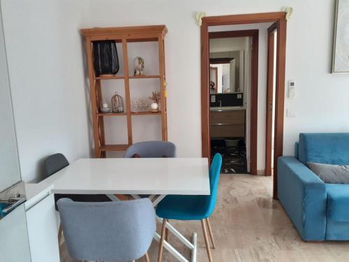 - un salon avec une table blanche et des chaises bleues dans l'établissement Au Cœur de Vence, à Vence