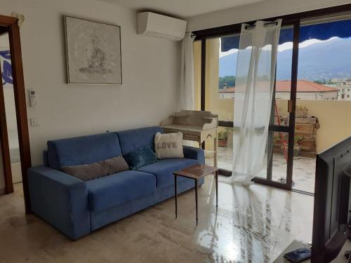 un salon avec un canapé bleu et une télévision dans l'établissement Au Cœur de Vence, à Vence