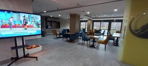 a living room with a large tv and a table and chairs at New Wolf in Bran