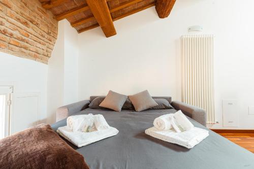 a bedroom with a bed with towels on it at Mansarda Colombo - Car Parking in Ferrara