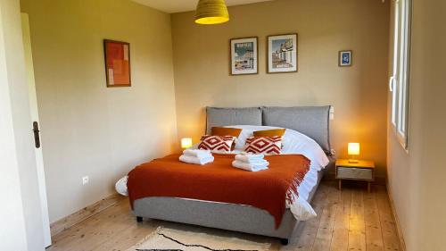 a bedroom with a bed with orange and white pillows at Villa L'oie bleue-Terrasse- Plage 5 min vélo in Wimereux