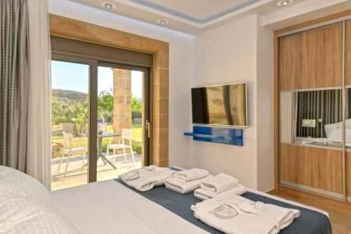 a bedroom with a bed with towels on it at Larimar Luxury Sea View Villa in Kissamos