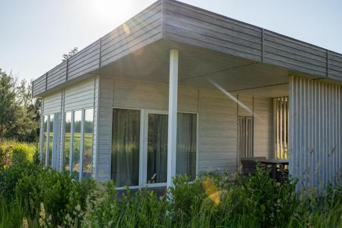 a house with sliding glass doors in a garden at Парк природи Беремицьке та Парк-готель Лісове Озеро in Beremytske