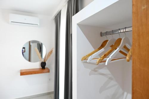 a walk in closet with white walls and a mirror at Beachfront cycladic suite Irene Apartments boutique hotel in Kanala