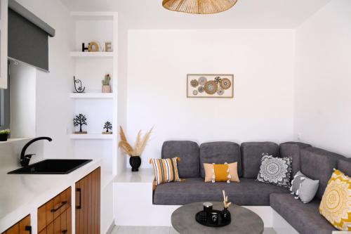 a living room with a couch and a table at Beachfront cycladic suite Irene Apartments boutique hotel in Kanala