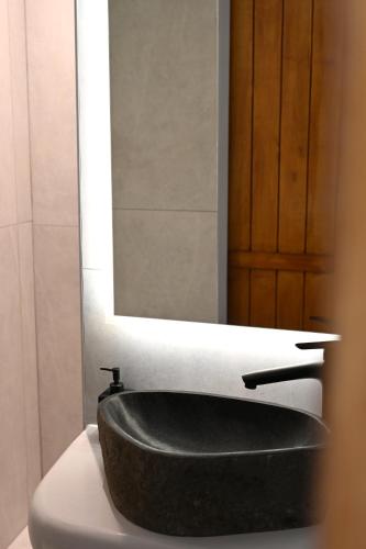 a bathroom with a black sink and a mirror at Beachfront cycladic suite Irene Apartments boutique hotel in Kanala