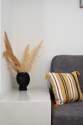 a vase with feathers on a table next to a couch at Beachfront cycladic suite Irene Apartments boutique hotel in Kanala