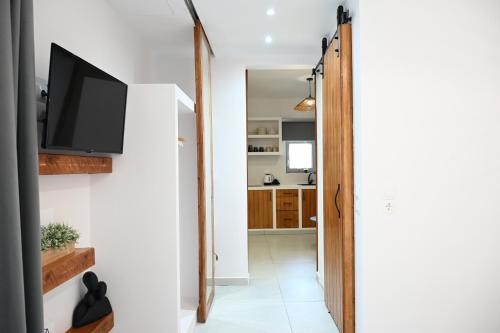 a hallway with a flat screen tv on a wall at Beachfront cycladic suite Irene Apartments boutique hotel in Kanala