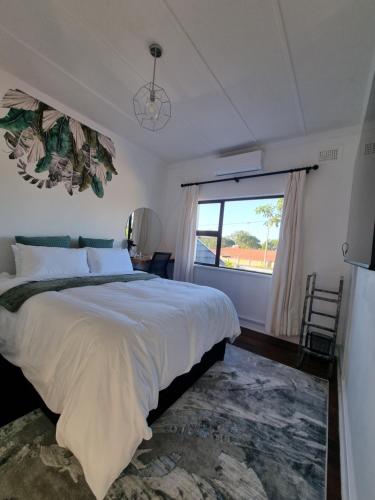 Un dormitorio con una cama grande y una ventana. en Troon Harmony - Room 2, en Durban