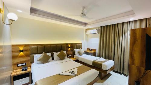 a hotel room with two beds and a television at Hotel Arma Residency in Mumbai