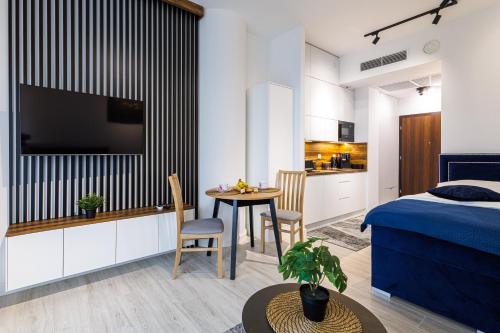 a bedroom with a bed and a small table with chairs at Apartament Hanza Tower 218 in Szczecin