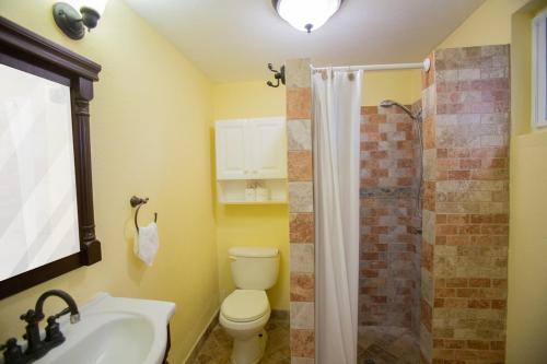 a bathroom with a toilet and a sink and a shower at Ocean Villa Guam in Tamuning