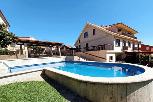 a swimming pool in the backyard of a house at Apartamentos Ababides in Baiona