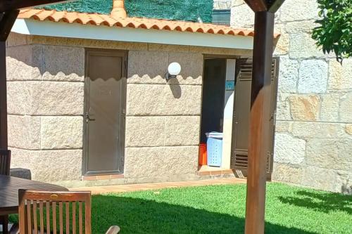 a stone house with a table and a door at Apartamentos Ababides in Baiona