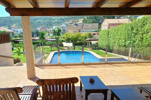 a patio with a pool and a table and chairs at Apartamentos Ababides in Baiona