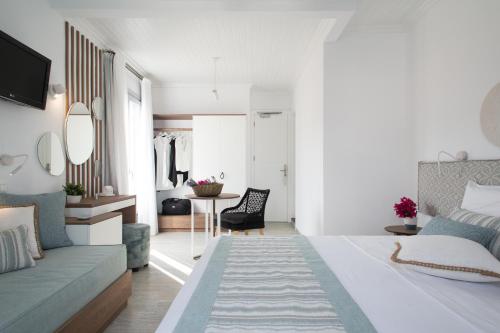 a bedroom with a bed and a living room at Aurora - Rooms & Suites - Spetses in Spetses