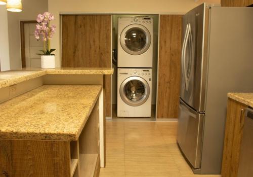 a kitchen with a refrigerator and a washer and dryer at Tumon Isa 16 Condo in Tamuning