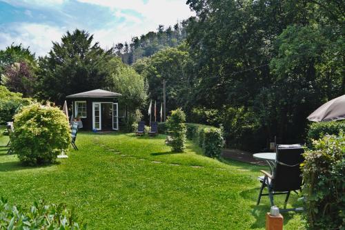 a garden with a gazebo and a table in the grass at BodeBude in Thale