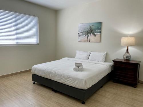 a bedroom with a bed with a teddy bear on it at Tumon Isa 16 Condo in Tamuning