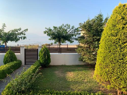 a garden with trees and a fence in the background at Sophie holiday house in Xylokastron
