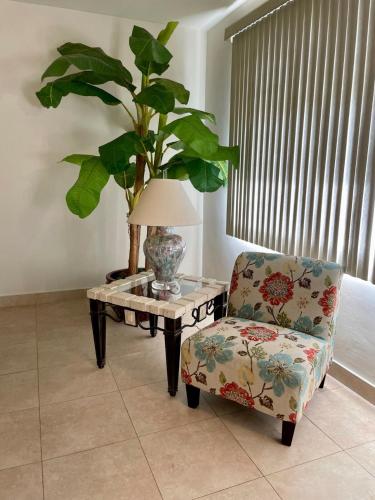 a living room with a table and a chair and a plant at Spacious 4bd25ba Retreat Near Hospital & Tumon in Tamuning