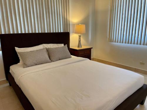 a bedroom with a large white bed with a window at Spacious 4bd25ba Retreat Near Hospital & Tumon in Tamuning