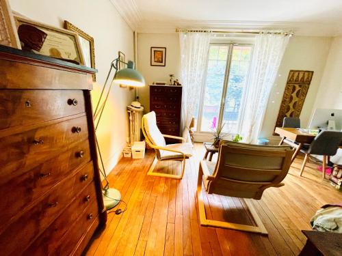 - un salon avec une commode, des chaises et une table dans l'établissement Paris Olympic Family Haven - Havre Familial Paris Olympique, à Paris