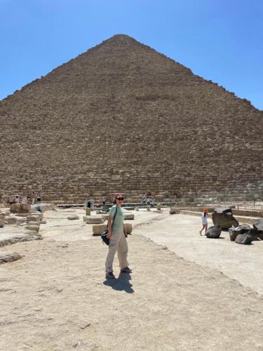 a woman standing in front of a pyramid at Diyar Pyramids Inn in Cairo