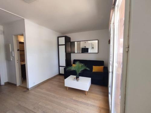 un salon avec un canapé et une table dans l'établissement Charmant appartement, Terrasse, Piscine, parking, à Mougins