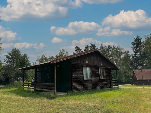 a small wooden cabin in a field with a sky at Chatová osada Bílý Kámen in Doksy