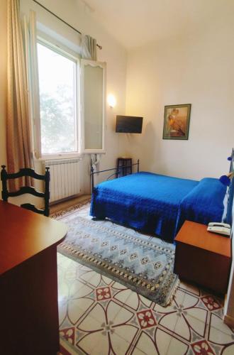 a bedroom with a blue bed and a window at Villa Al Piano in Lastra a Signa