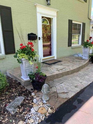 a house with two vases of flowers on a porch at Antique Charm Cozy 3br Retreat W Private Patio in Kettering