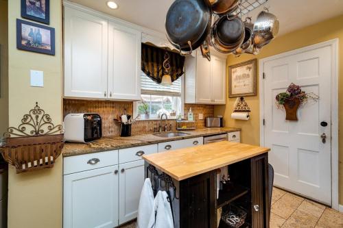 a kitchen with white cabinets and a wooden counter top at Antique Charm Cozy 3br Retreat W Private Patio in Kettering