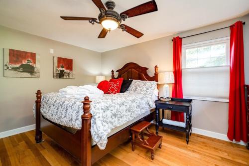a bedroom with a bed with red curtains and a ceiling fan at Antique Charm Cozy 3br Retreat W Private Patio in Kettering