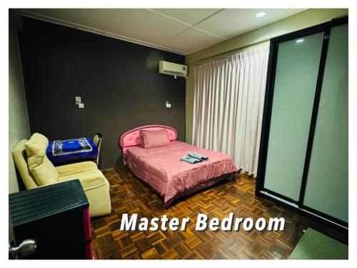 a bedroom with a bed and a chair and a tv at Taman Kemena Raya Bintulu Homestay in Bintulu