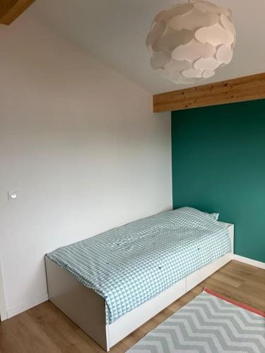 - une chambre dotée d'un lit avec un mur vert dans l'établissement Maison proche océan à tosse, à Tosse