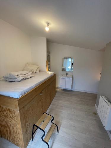a room with a bed with a wooden frame at Chambre privée dans maison d’hôtes in Cenon