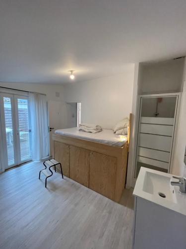 a room with a bed and a sink in it at Chambre privée dans maison d’hôtes in Cenon