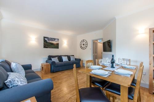 a living room with a table and a blue couch at The Tea House - A Stones Throw from Beach in Broadstairs