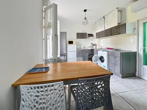 une cuisine avec une table et des chaises en bois dans l'établissement T2 climatisé au centre de Palavas, proche plage - FR-1-559-19, à Palavas-les-Flots