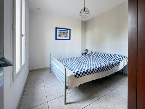 une chambre avec un lit avec un couvre-lit bleu et blanc dans l'établissement T2 climatisé au centre de Palavas, proche plage - FR-1-559-19, à Palavas-les-Flots