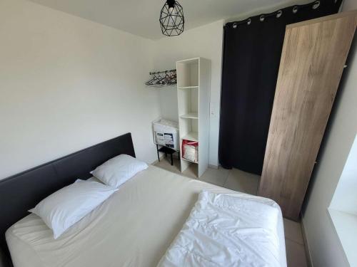- une chambre avec un lit blanc et une étagère dans l'établissement Studio cabine à Berck-Plage avec parking privé, wifi inclus, non-fumeur - FR-1-674-8, à Berck-sur-Mer