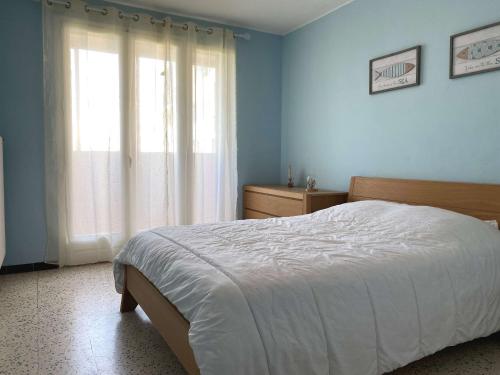 une chambre avec un lit et une grande fenêtre dans l'établissement Charmant T3, Proche Thermes, Parking Privé, Wifi, 2 Chambres, 2* - FR-1-553-196, à Balaruc-les-Bains