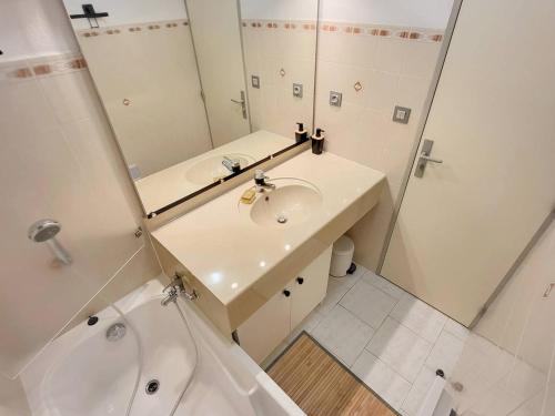 une salle de bain avec un lavabo, un miroir et une baignoire dans l'établissement Appartement T2 + Coin Nuit, Parking, Piscine/Tennis, à 200m Plages/Commerces - FR-1-316-323, à Six-Fours-les-Plages